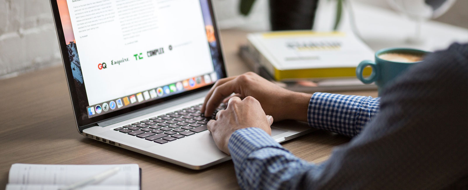 Digital marketing professional working on a laptop, with press features from GQ, Esquire and other publications